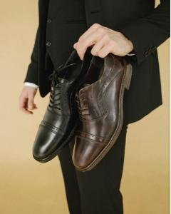 Zapato De Vestir Para Hombre Café Oscuro En Piel Vacuno Satinada Sostenido En Mano