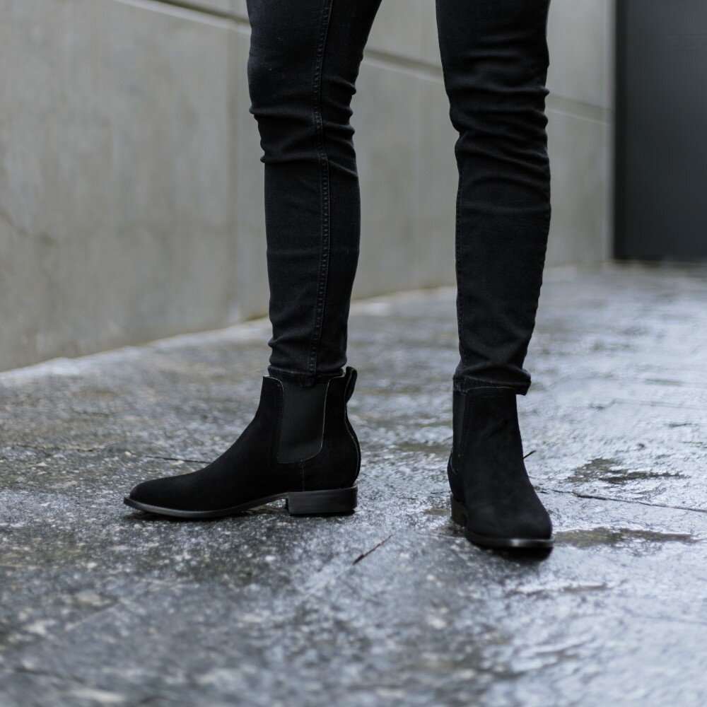 Botines Chelsea de gamuza negra para hombre usados en entorno urbano