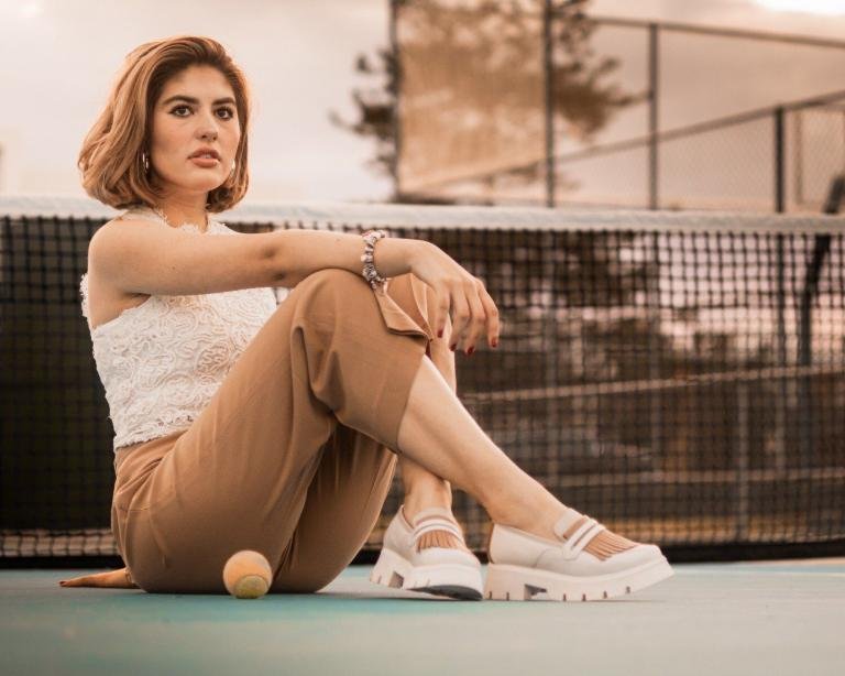 Mujer sentada usando penny loafer chunky late con café en outfit casual elegante mostrando cómo combinar mocasines contemporáneos