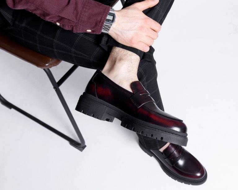 Detalle de penny loafer chunky vino para hombre en piel vacuno acabado camaleón combinado con pantalón formal moderno