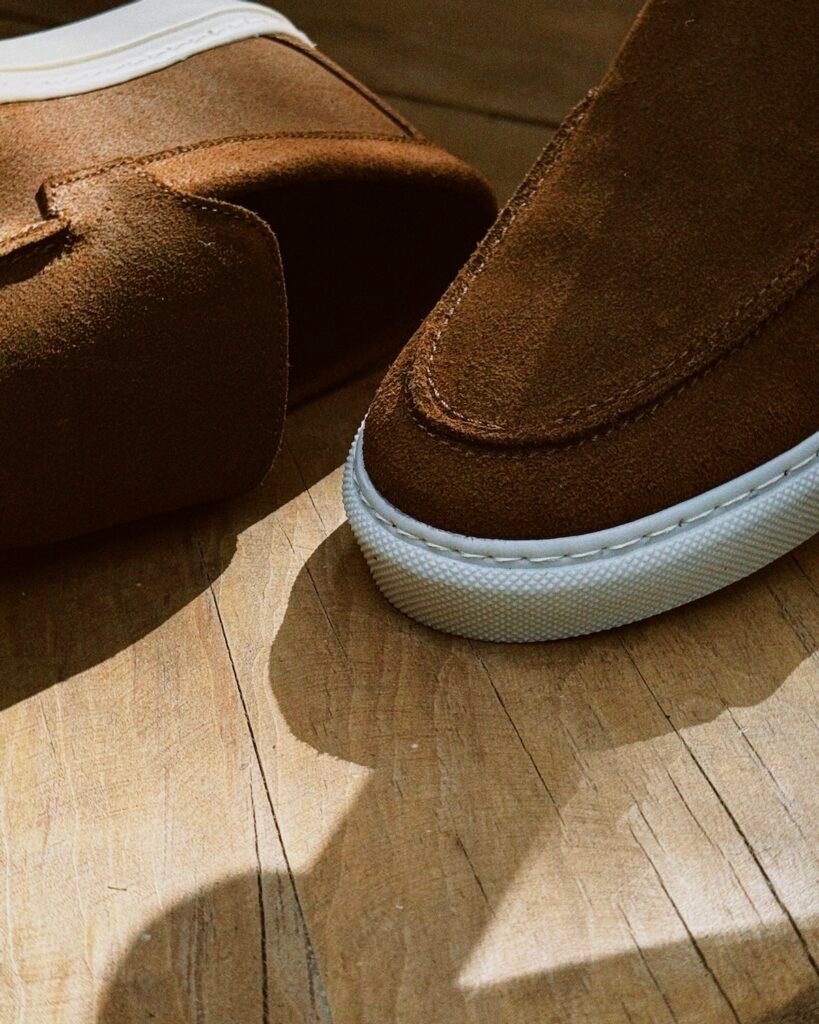 Closeup de mocasines de gamuza café para hombre con textura detallada y acabado que resiste suciedad y uso en exteriores