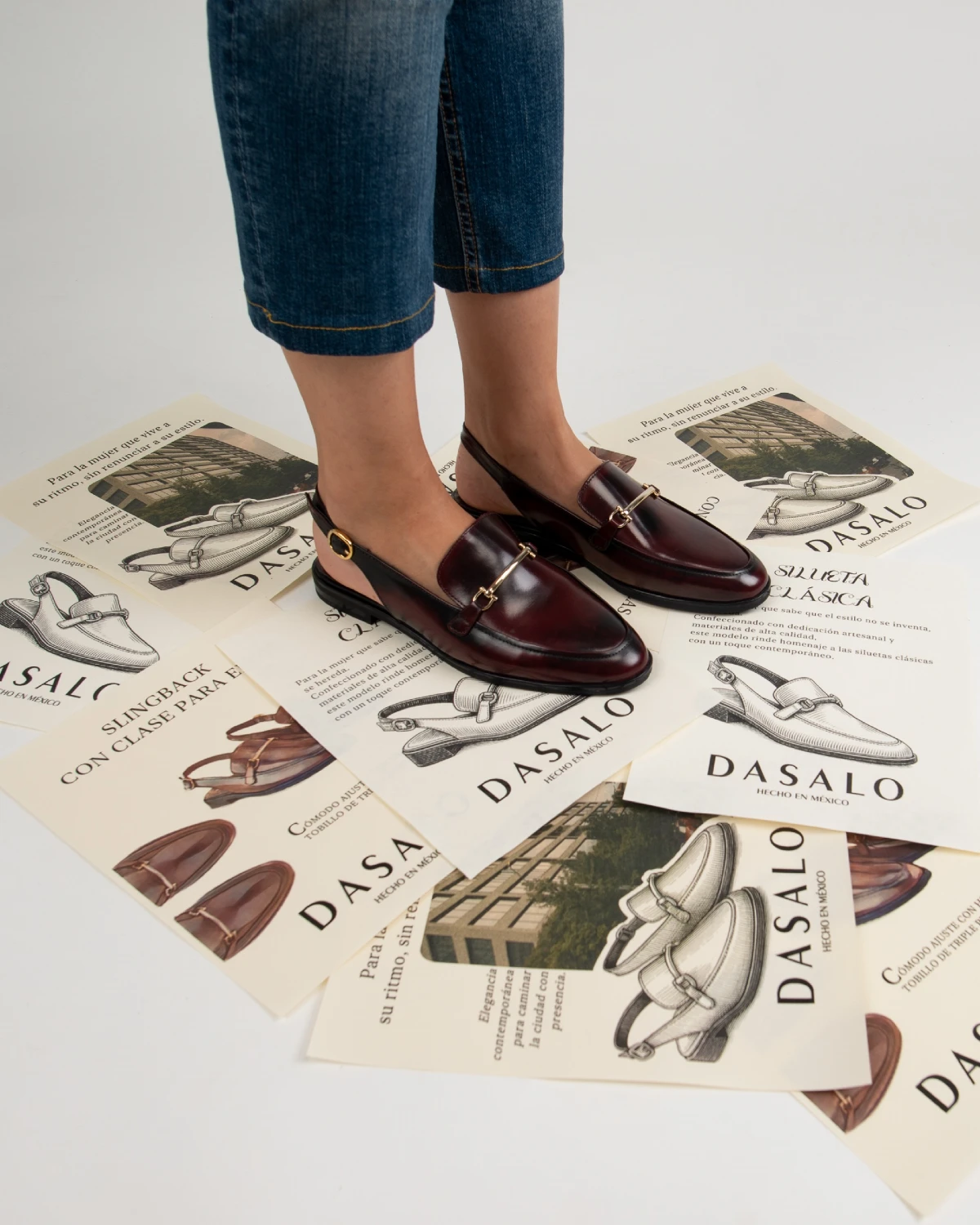 Mujer usando mocasines destalonados color vino con jeans azules en un outfit casual.
