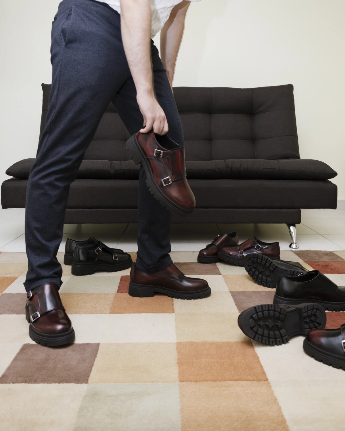 Hombre con zapatos monkstrap color vino y pantalón gris oscuro en un outfit formal.