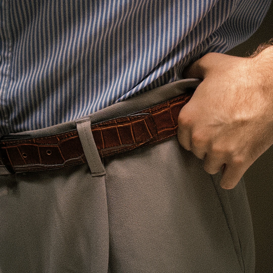 inturón de piel vacuno café con textura cocodrilo usado con camisa azul y pantalón de vestir
