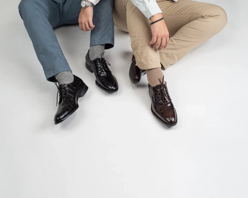 Zapatos modernos de vestir tipo derby con grabado combinados con pantalón azul de vestir y chinos beige para un estilo de oficina casual.