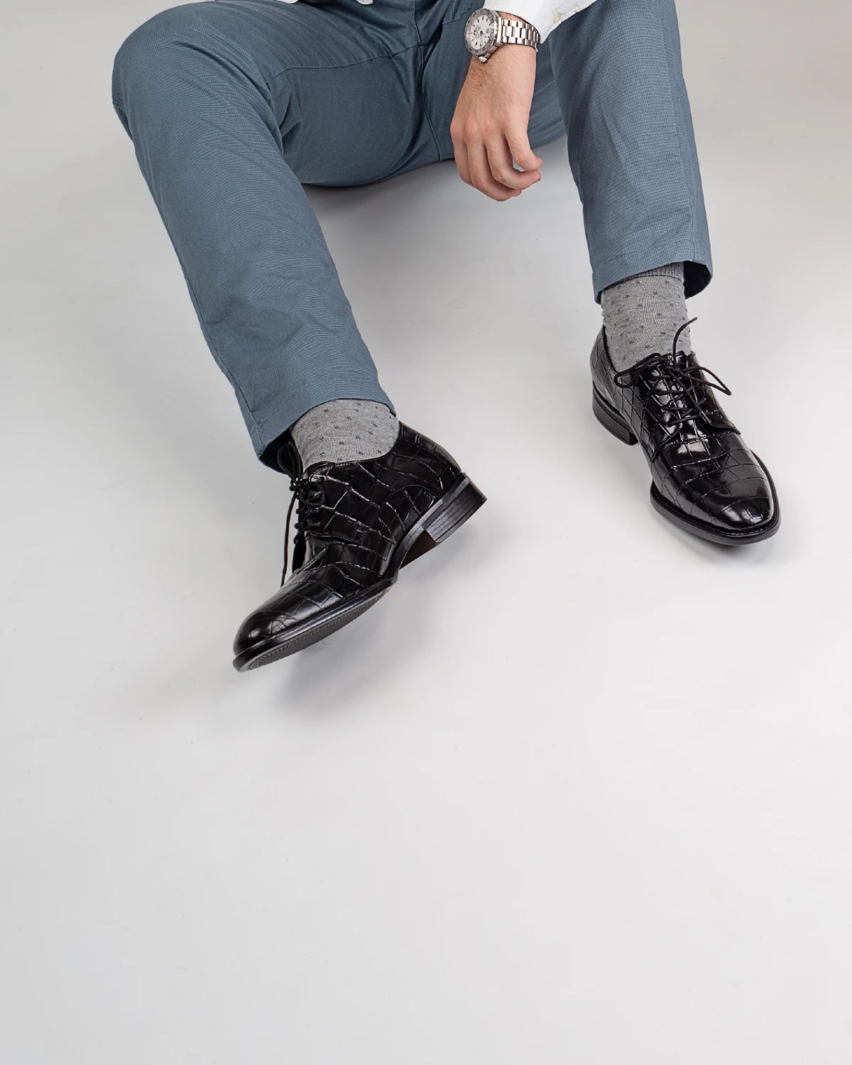 Zapato moderno de vestir estilo derby en piel negra con textura tipo lagarto, calzado con cordones elegante para hombre.