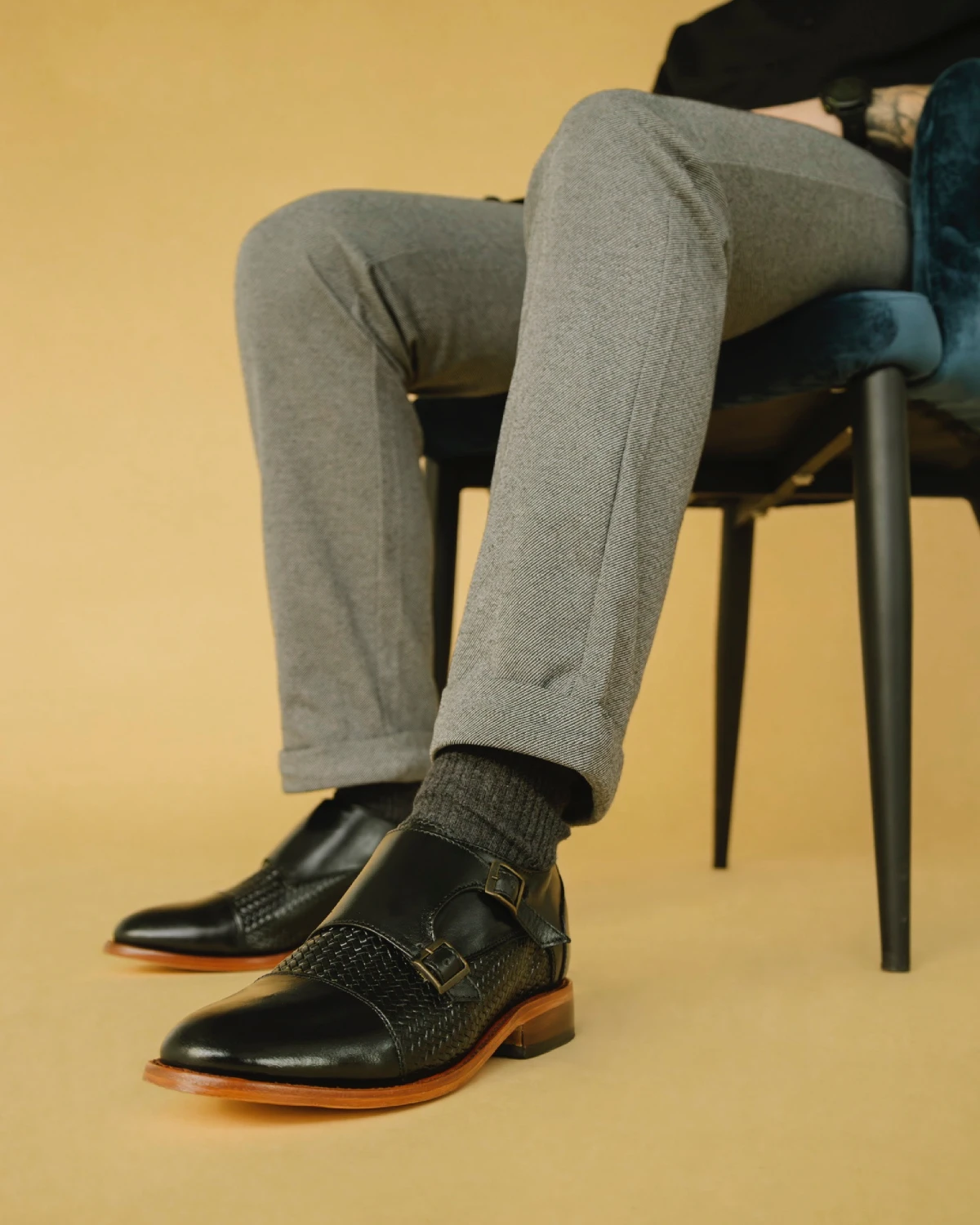 Zapato moderno de vestir estilo monkstrap de doble hebilla en piel negra con detalles grabados, ideal para un look formal elegante.