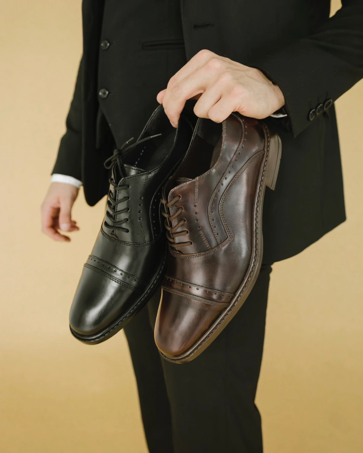 Zapato moderno de vestir estilo oxford clásico con detalles brogue en colores negro y café, calzado formal elegante para hombre.