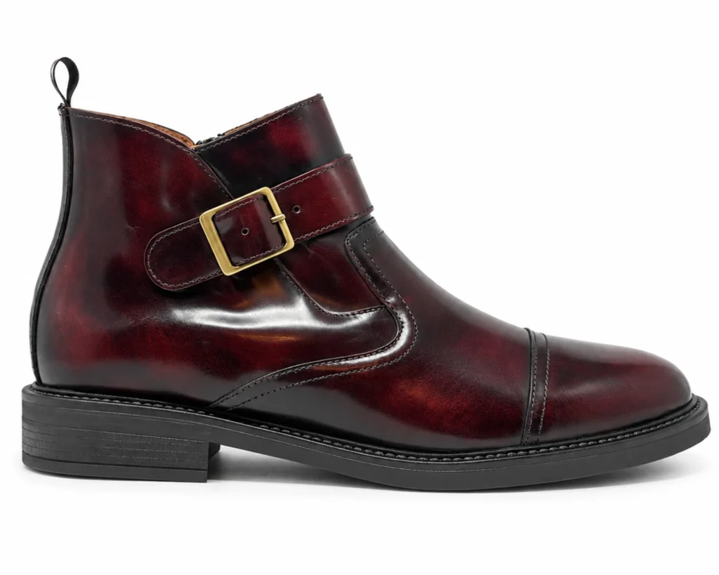 Bota de inspiración Jodhpur para hombre en piel acabado camaleón vino, con correa ajustable, hebilla dorada y costura transversal en la puntera.